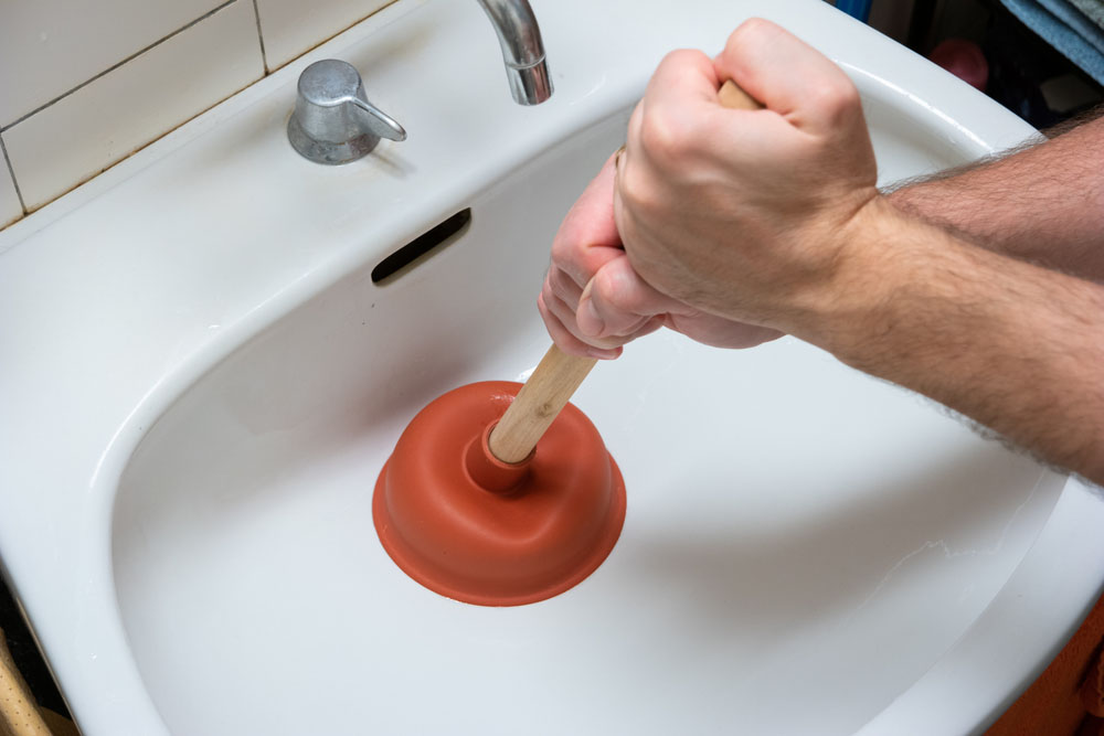 a person holding a plunger